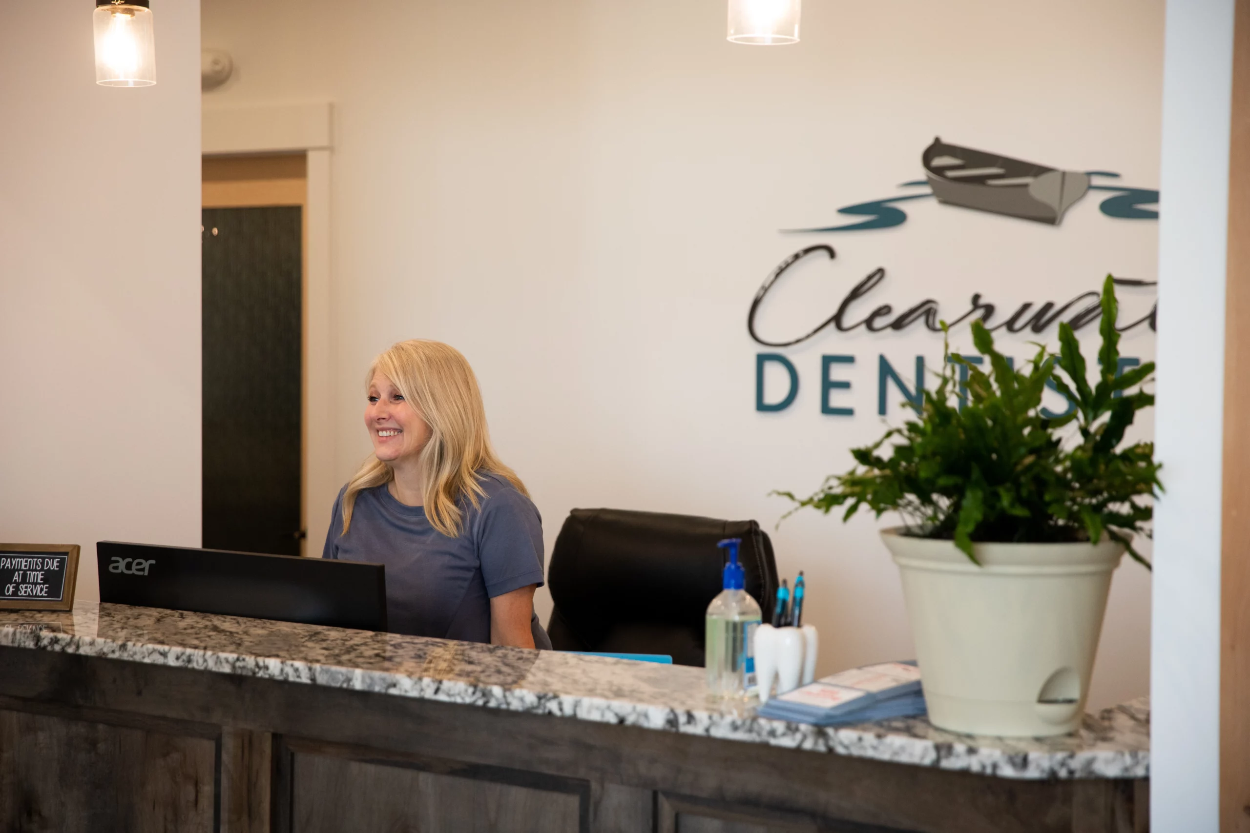 Clearwater Family Dental Care team member welcoming patients at the front desk in a clean, modern dental office
