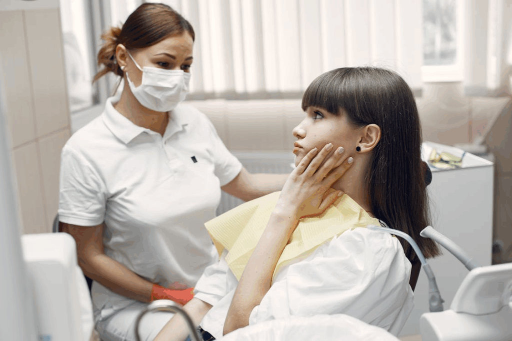 a woman talking to the dentist, complaining of a tooth ache